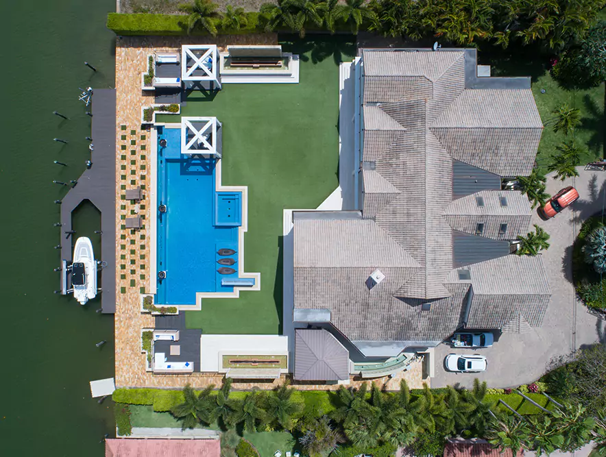 Aerial view of a luxury home with a pool and dock on the waterfront